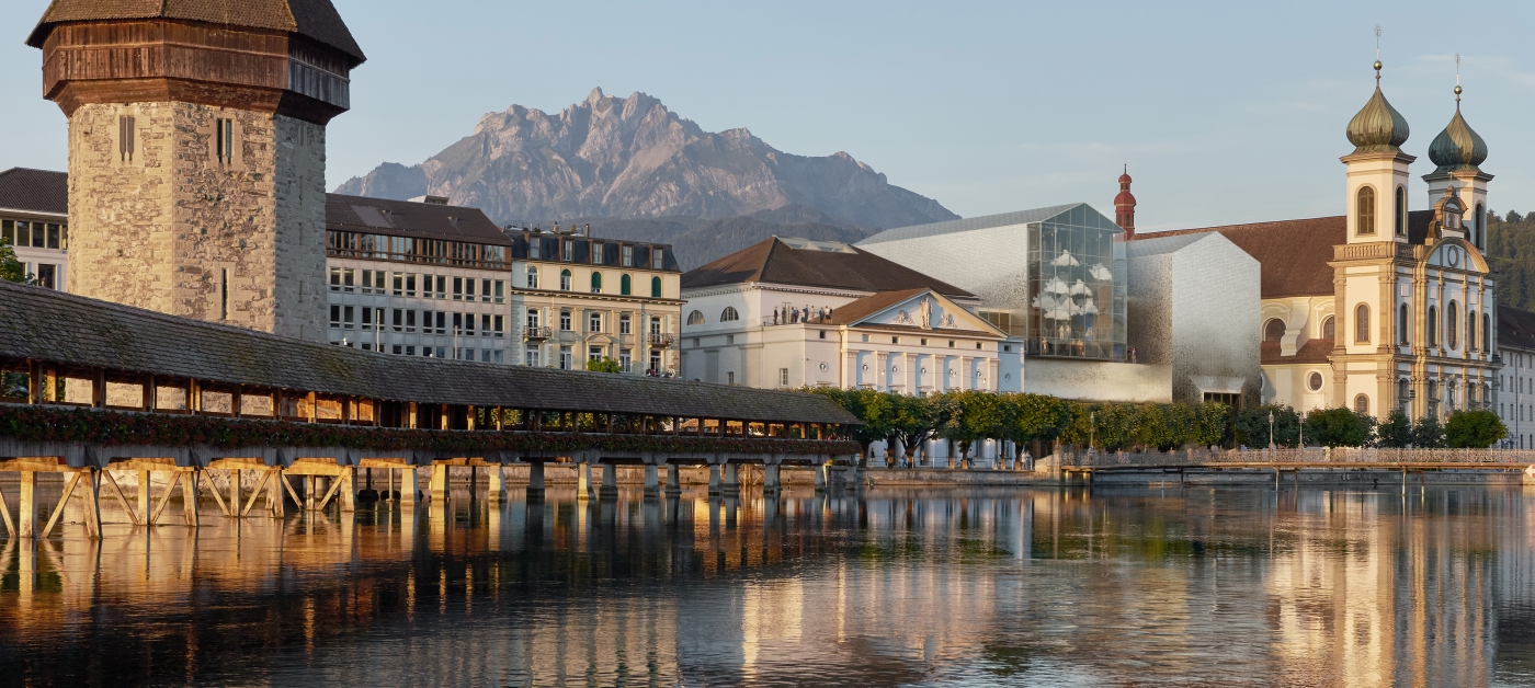 Das Neue Luzerner Theater auf einer Modellaufnahme. Drei Trümpfe unter vielen: a) Das bestehende Theater verbindet das Damals mit dem Heute; b) die von der Pilatus-Silhouette bekrönte Giebel-Landschaft hat prägende Kraft; c) die Jesuitenkirche behält ihren grossen Auftritt. 